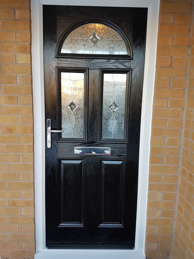 Black composite door with woodgrain finish